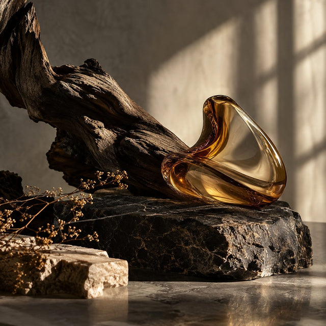Editorial artwork for Alessandro Gualtieri: dark sculptural driftwood, black stone, a single abstract amber glass shape and dramatic shadows.